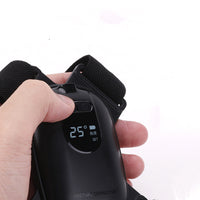 Close-up of a hand pressing the posture trainer power button beside its digital display